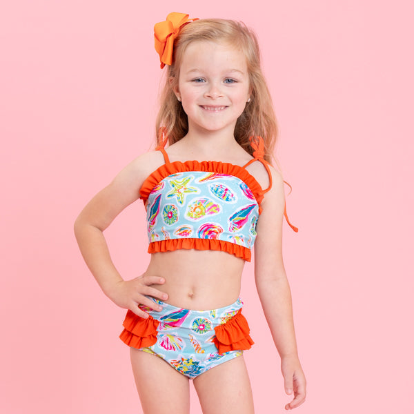 young girl wears seashell swimsuit