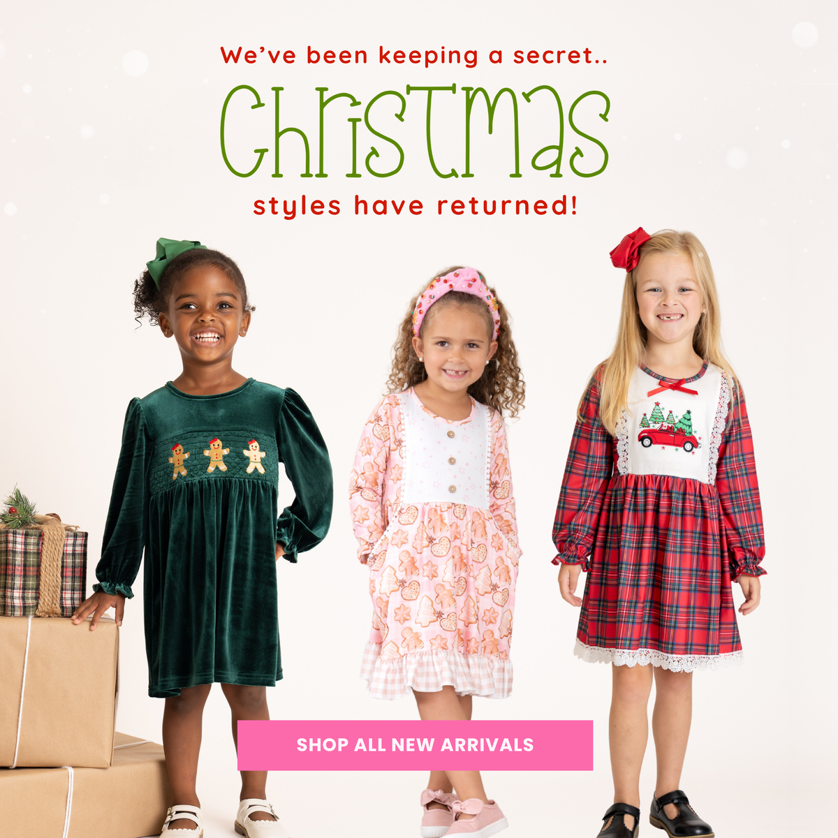 Three young girls modeling Christmas-themed dresses against a white background with promotional text reading 'We've been keeping a secret.