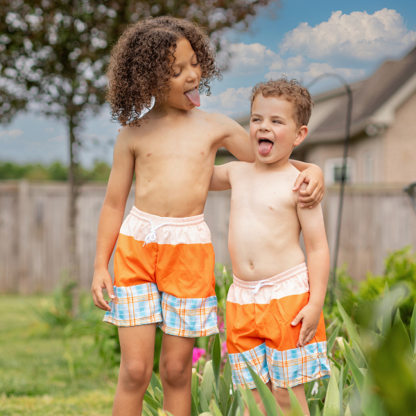 two boys wearing matching orange swimsuits