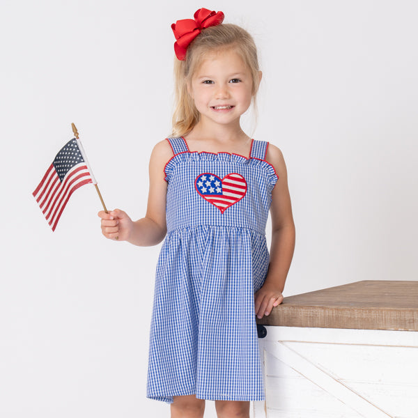 young girl wearing patriotic USA dress holding american flag