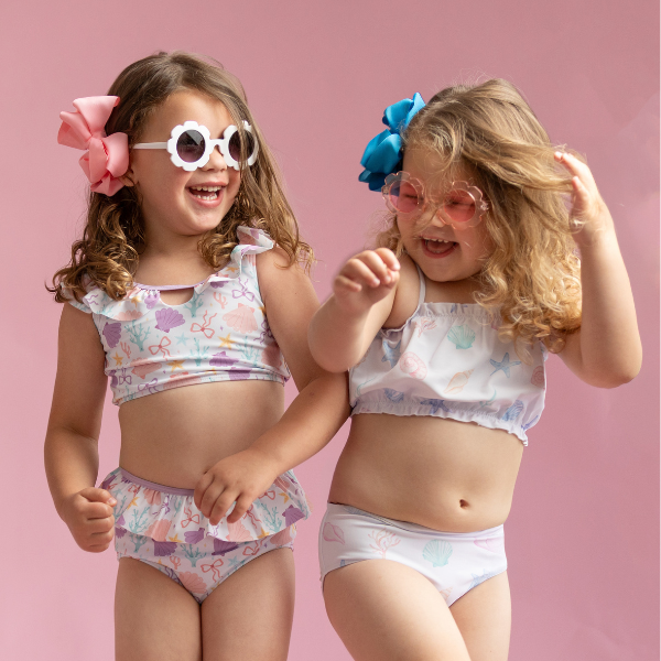 two young girls wearing two piece swimsuits